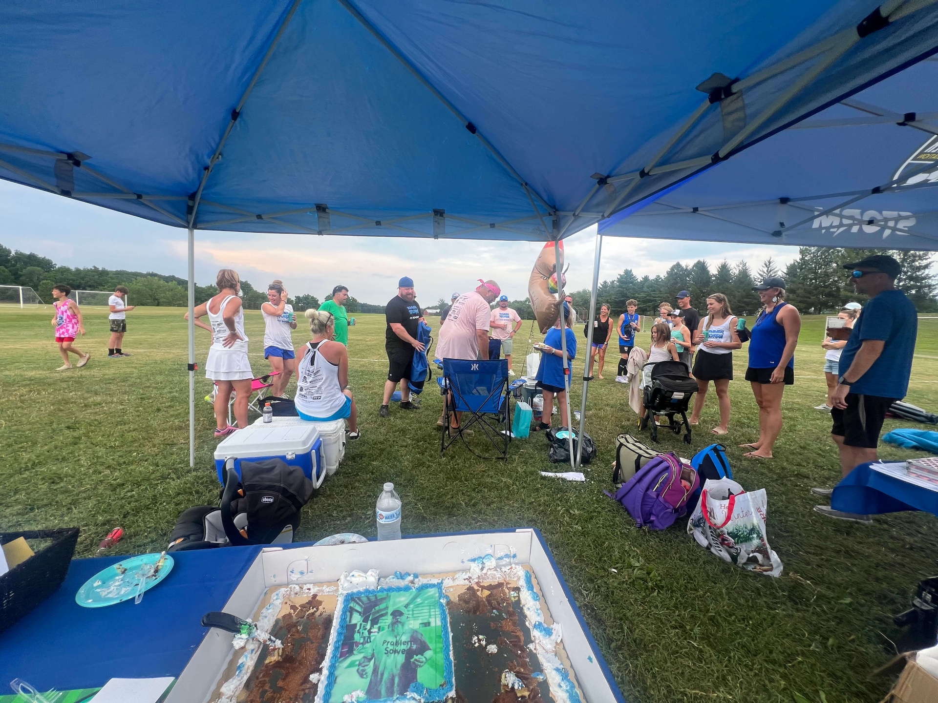 2025 — Coaches and families celebrating under the Storm tent