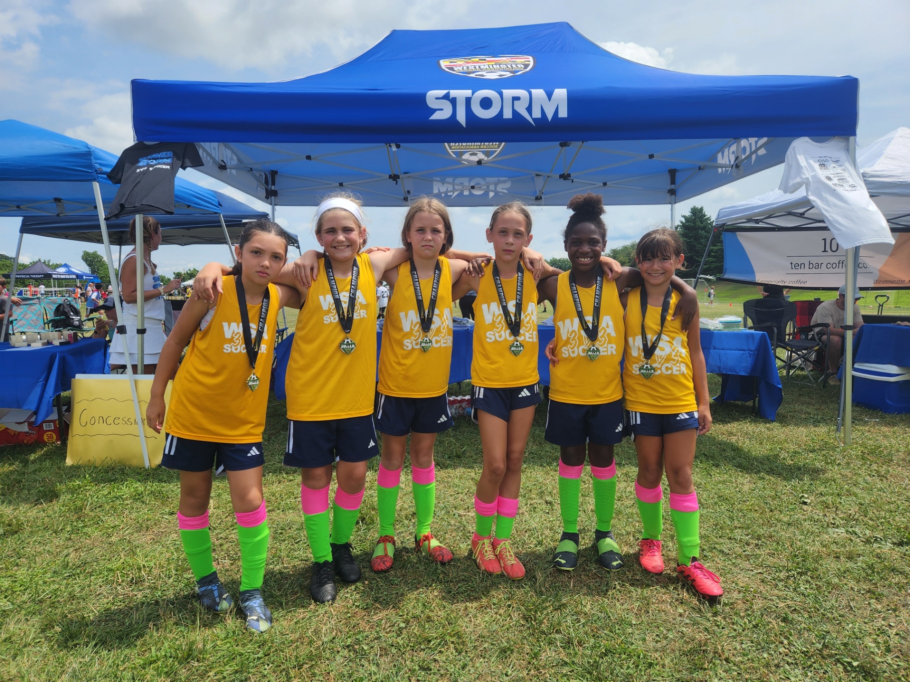 2025 — WSA girls team with championship medals under the Storm tent