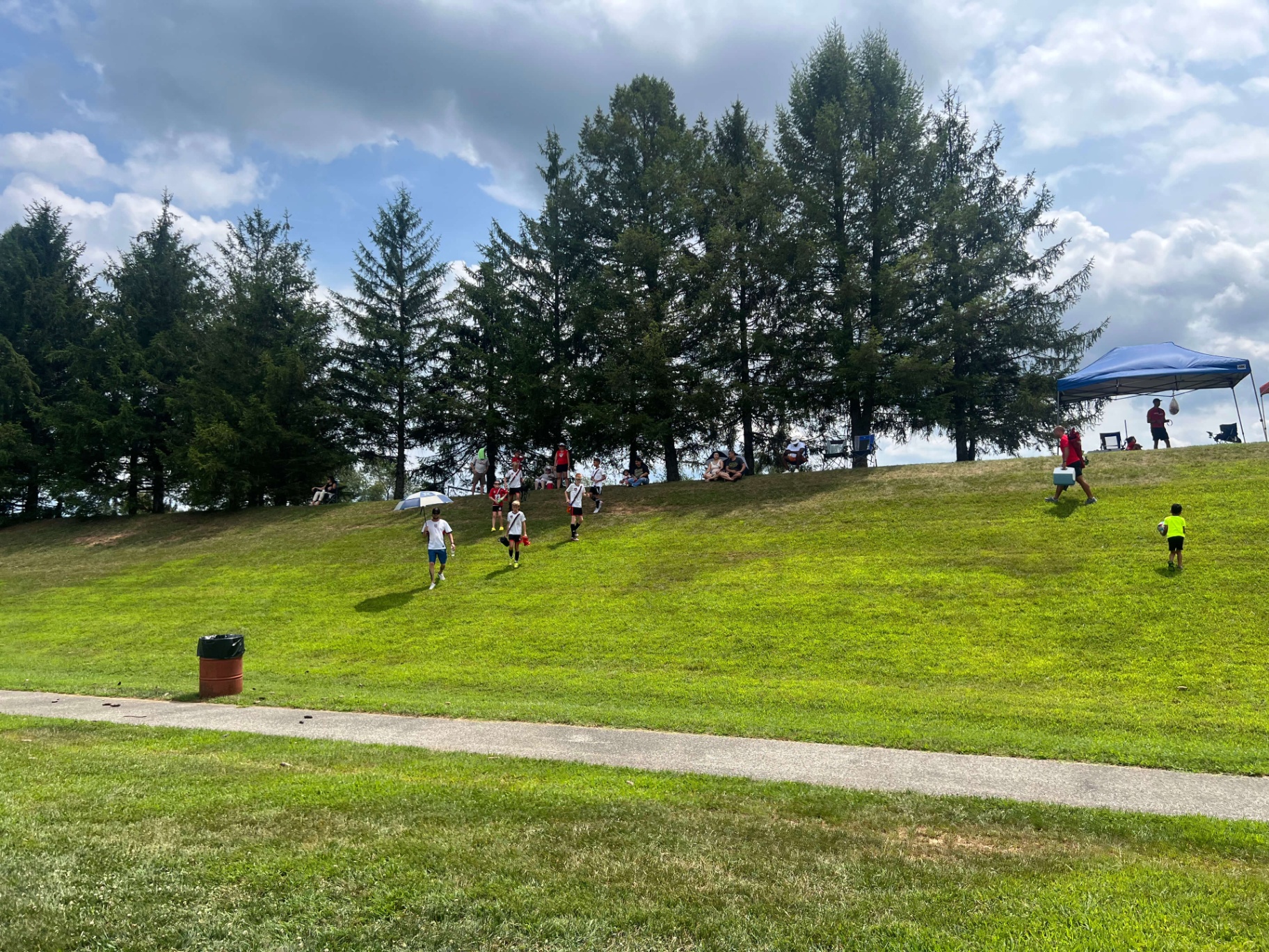 Spectators on the hill watching matches in the shade
