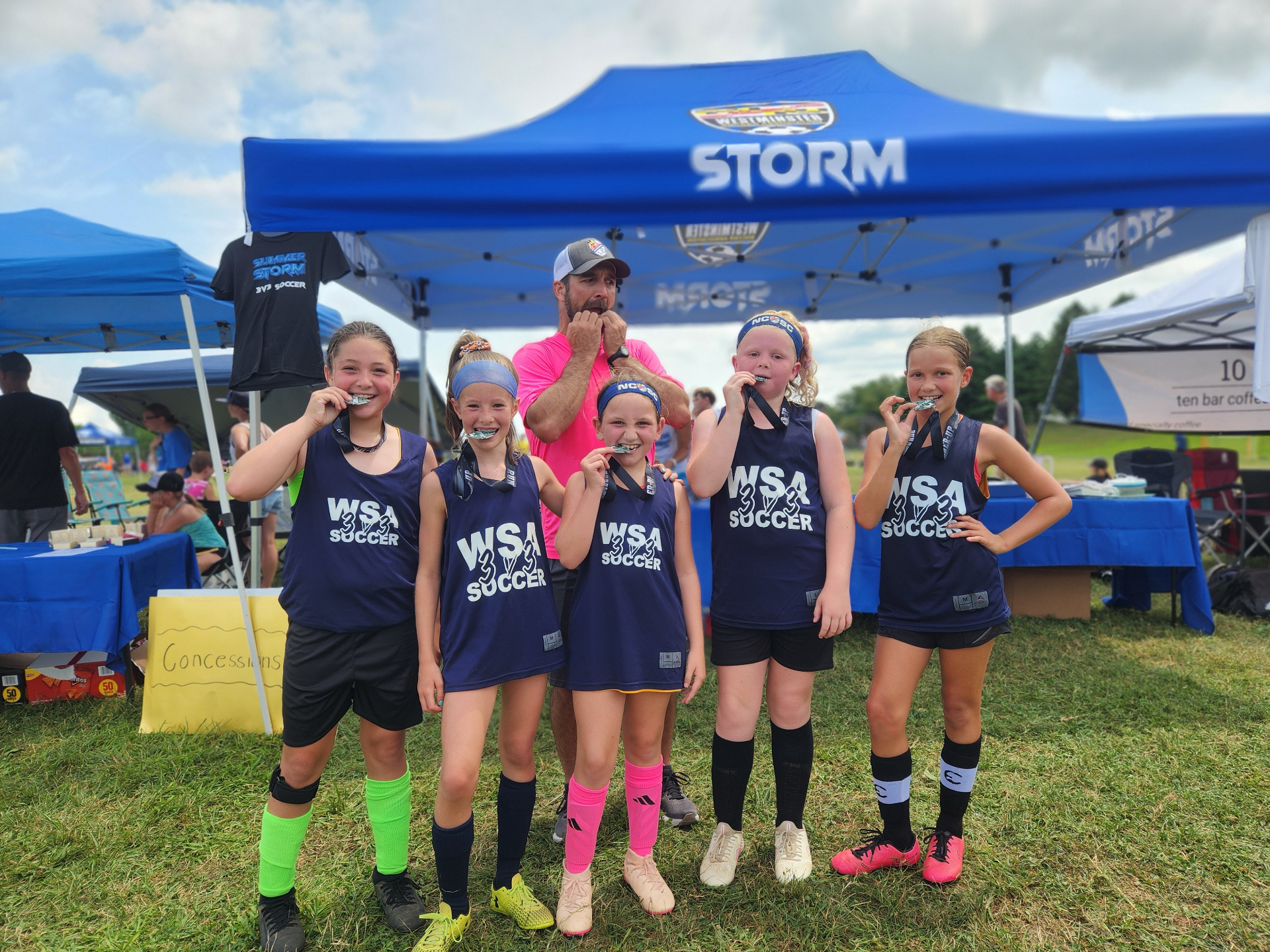 WSA girls team biting their medals after the championship