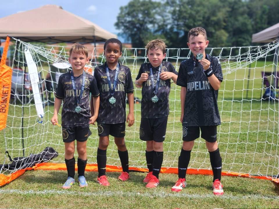 Pipeline team showing medals in front of the goal